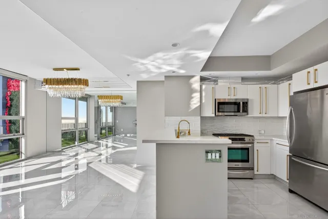 a kitchen with stainless steel appliances kitchen island granite countertop a sink refrigerator and cabinets