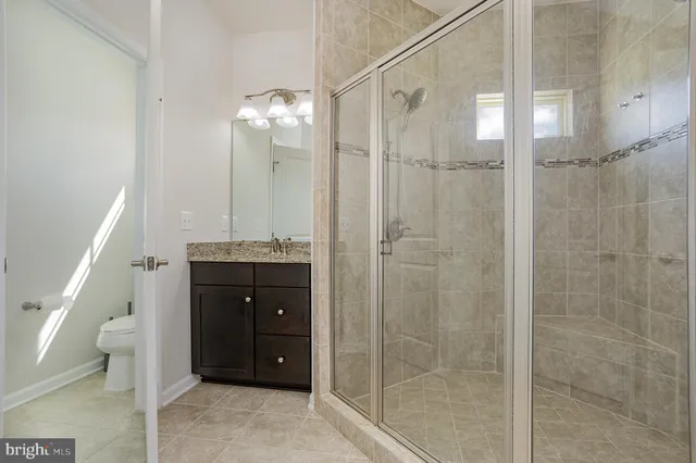 a bathroom with a granite countertop sink shower and a mirror
