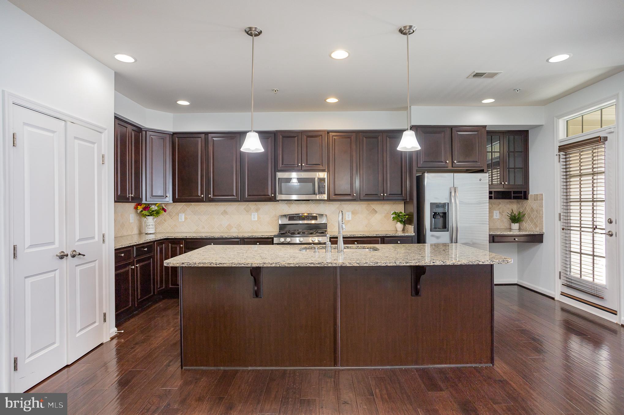 25890 Racing Sun Drive Aldie, VA 20105 - Photo 3 of 25 a kitchen with kitchen island stainless steel appliances a sink a stove a refrigerator a center island and a window