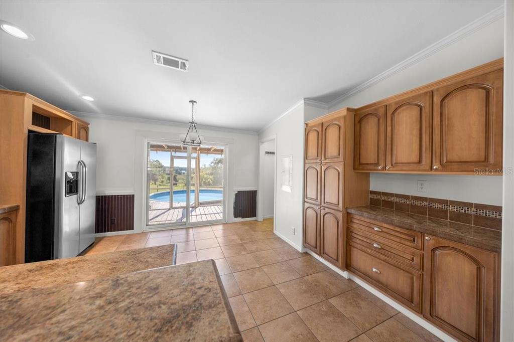 17355 Southeast 260th Avenue Road Umatilla, FL 32784 - Photo 13 of 69 a kitchen with stainless steel appliances granite countertop a refrigerator stove and cabinets