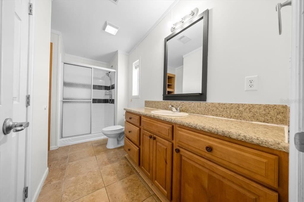 17355 Southeast 260th Avenue Road Umatilla, FL 32784 - Photo 23 of 69 a spacious bathroom with a granite countertop sink a toilet and a mirror