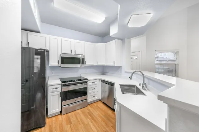 a kitchen with a sink stainless steel appliances and cabinets
