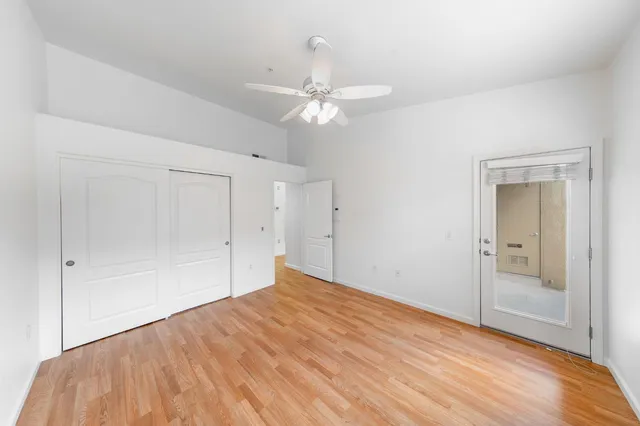 a view of a big room with wooden floor and a chandelier fan