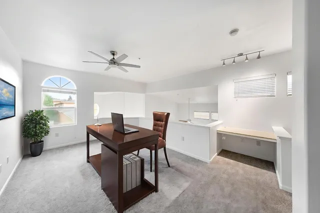 a view of a livingroom with a ceiling fan and window