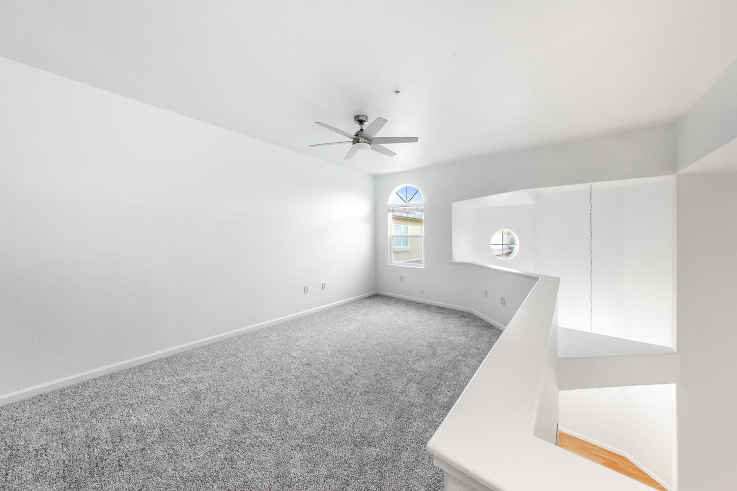 1900 Danbrook Drive, Unit 1222 Sacramento, CA 95835 - Photo 43 of 51 an empty room with chandelier fan and windows