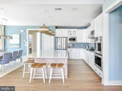 a large kitchen with white cabinets and stainless steel appliances