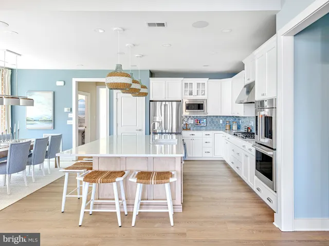 a large kitchen with white cabinets and stainless steel appliances
