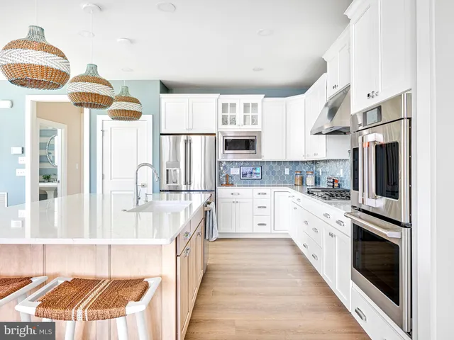 a large kitchen with cabinets and wooden floor