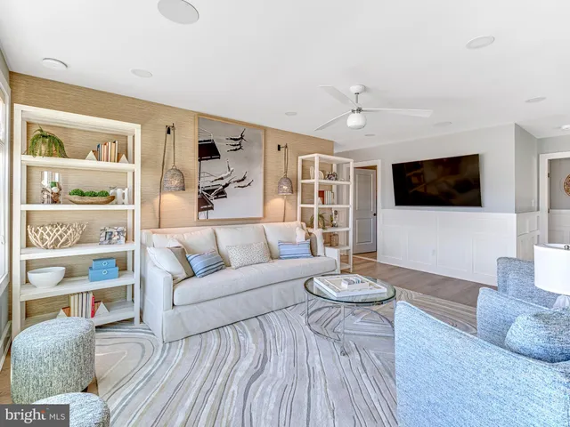 a living room with furniture a flat screen tv and a hard wood floor
