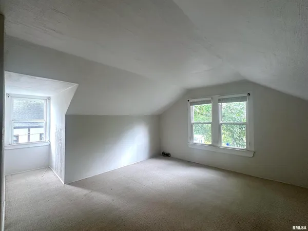 an empty room with windows and closet