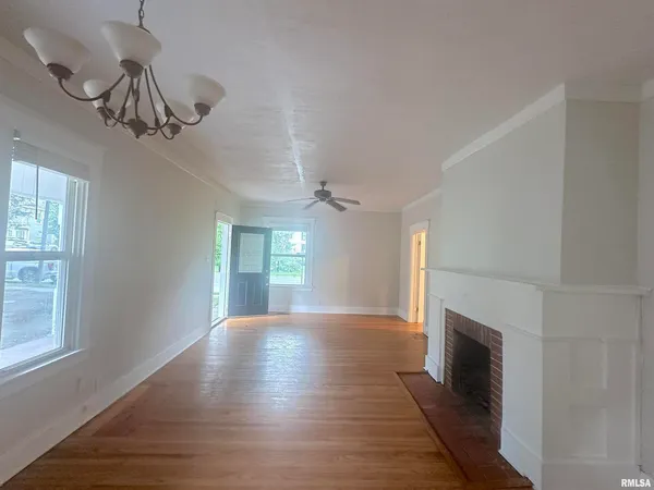 a view of empty room with wooden floor and fireplace