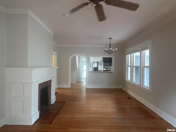 a view of empty room with wooden floor and fireplace