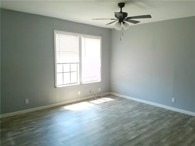 an empty room with a window and a ceiling fan