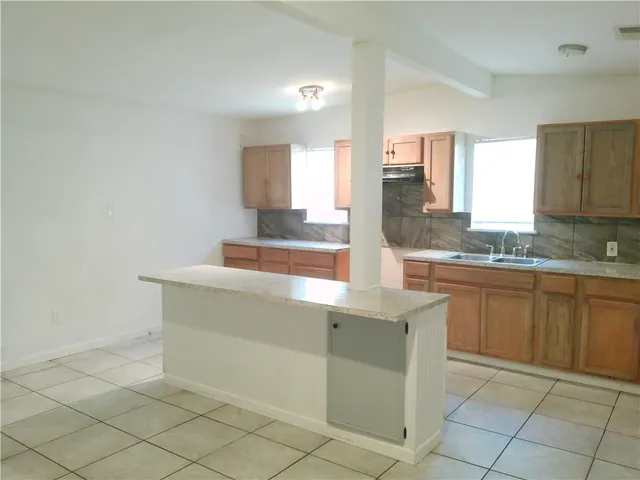a kitchen with cabinets and window