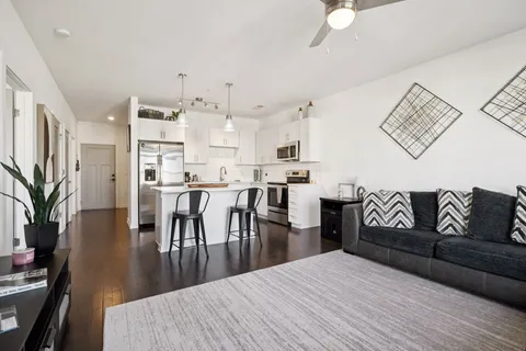 a living room with kitchen island furniture and a kitchen view