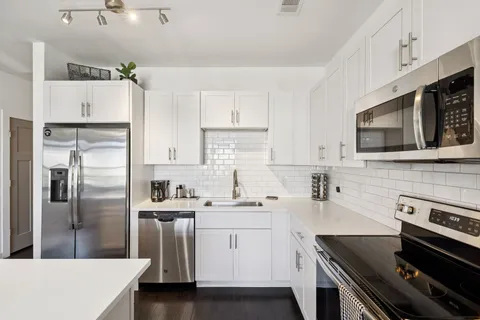 a kitchen with stainless steel appliances a sink stove and refrigerator