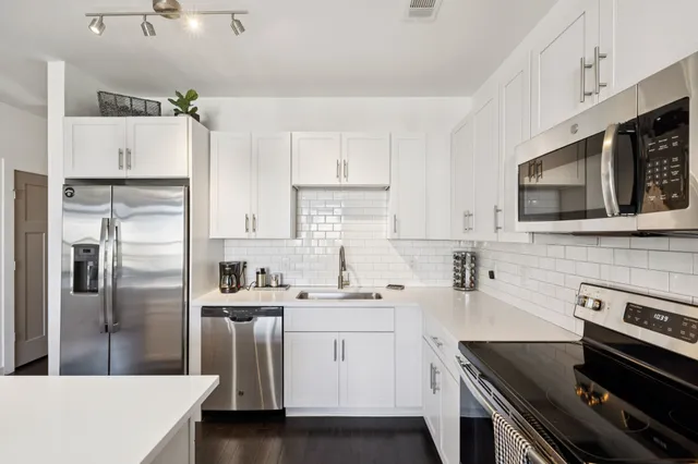 a kitchen with stainless steel appliances a sink stove and refrigerator