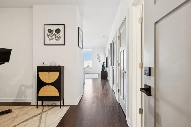a view of a hallway with wooden floor and furniture