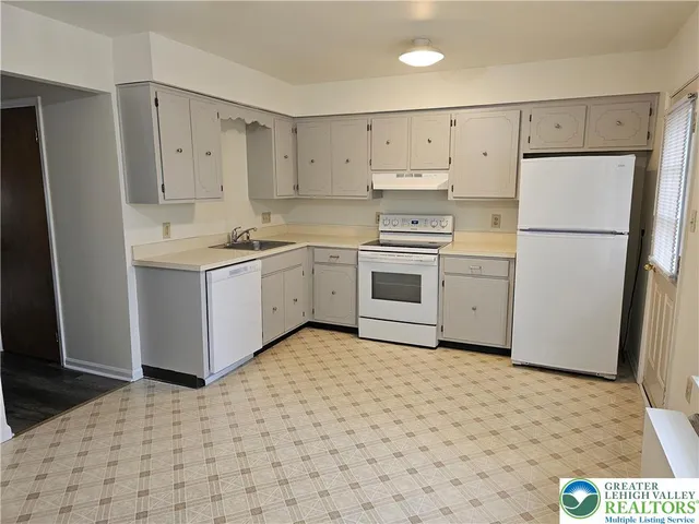 a kitchen with a stove a refrigerator and a sink