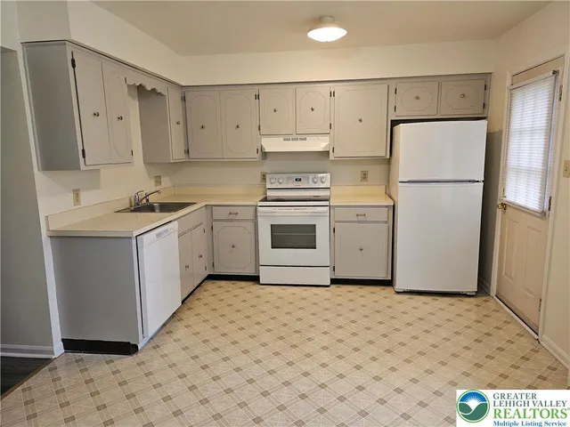 a kitchen with a white cabinets and white appliances