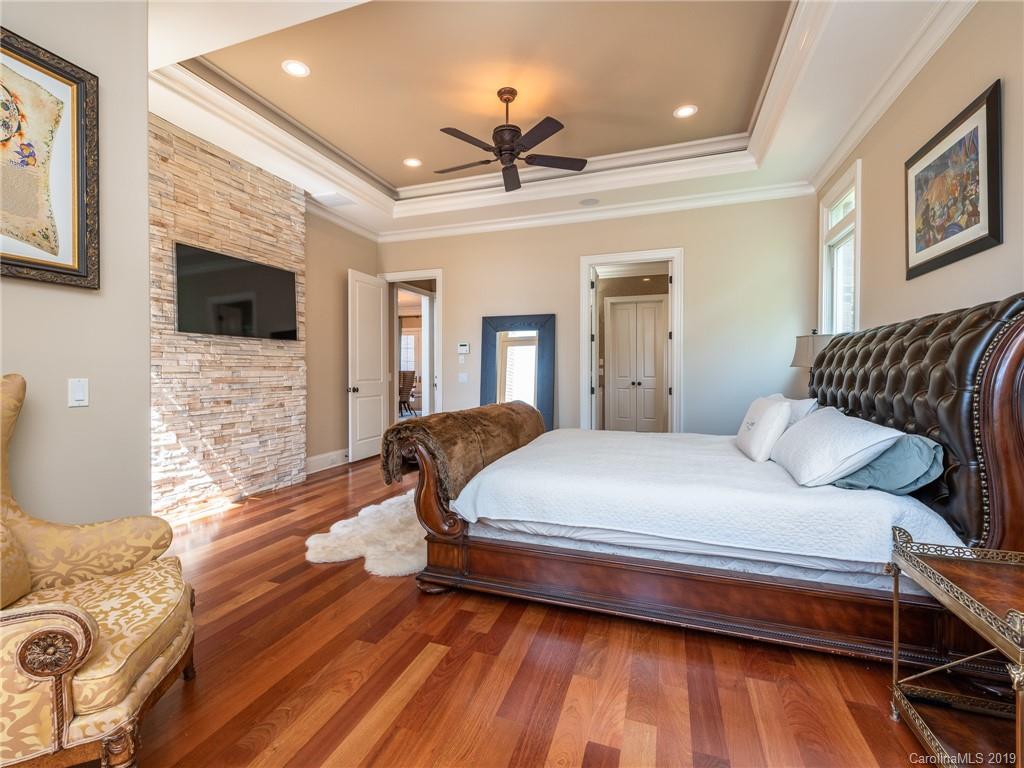 18424 Nantz Road Cornelius, NC 28031 - Photo 14 of 47 a bedroom with a bed wooden floor and flat screen tv