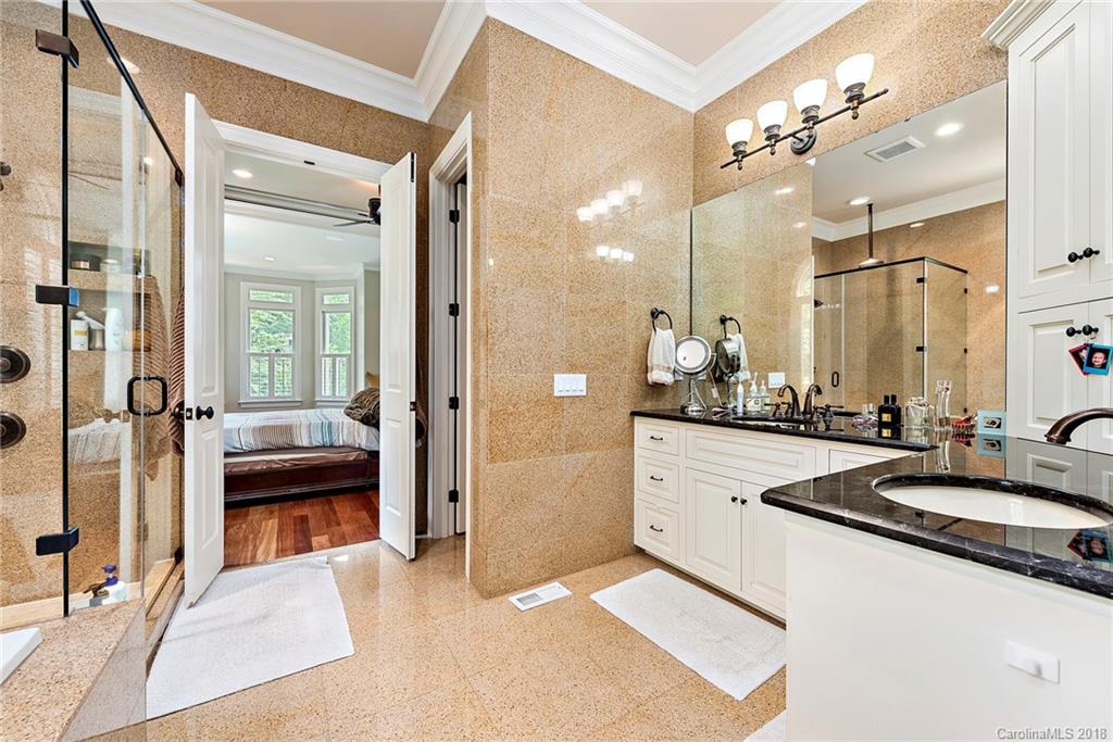 18424 Nantz Road Cornelius, NC 28031 - Photo 15 of 47 a bathroom with a sink a large mirror and a glass door shower