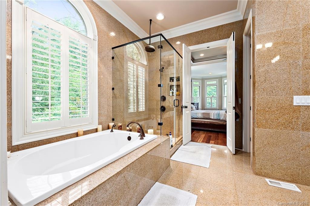 18424 Nantz Road Cornelius, NC 28031 - Photo 16 of 47 a spacious bathroom with a tub shower and mirror