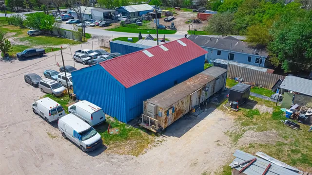 an aerial view of residential houses with outdoor space and trees