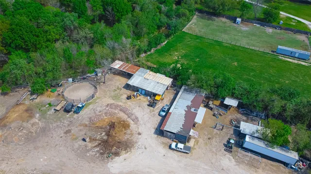 an aerial view of residential houses with outdoor space and trees