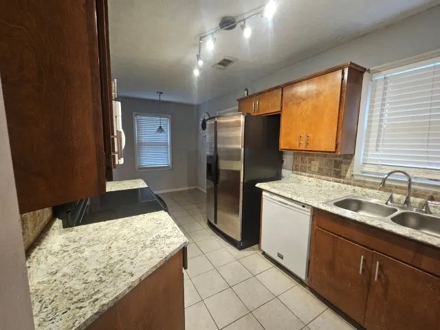 a kitchen with stainless steel appliances granite countertop sink refrigerator and microwave