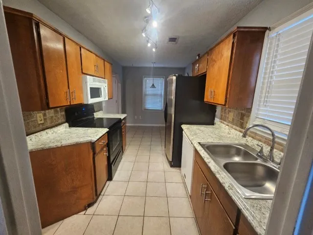 a kitchen with a stove sink and a refrigerator
