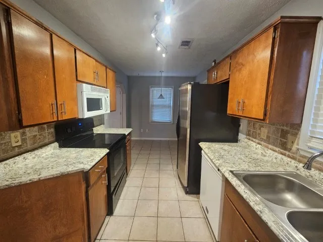 a kitchen with a sink stove and refrigerator