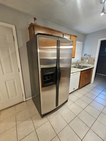 a kitchen with granite countertop a refrigerator and a stove