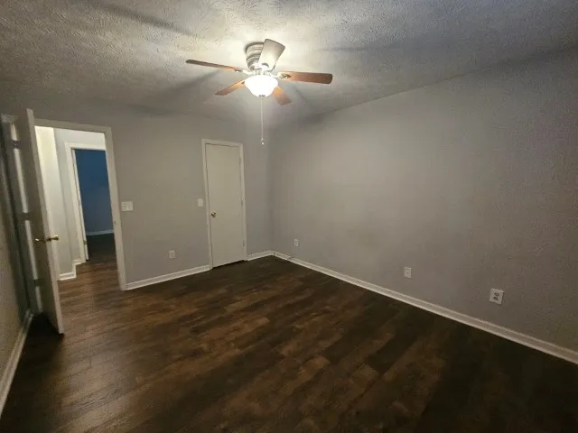 an empty room with wooden floor and chandelier fan