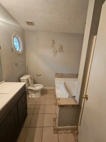a spacious bathroom with a toilet sink and mirror