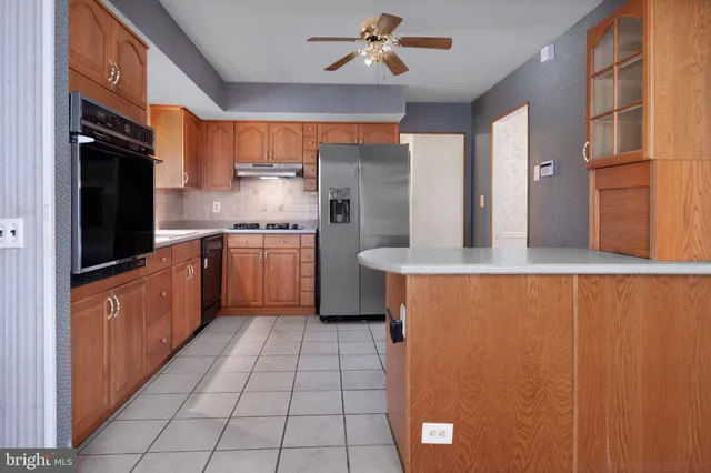 a large kitchen with stainless steel appliances granite countertop a refrigerator and a sink