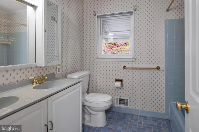 a bathroom with a granite countertop toilet and a sink
