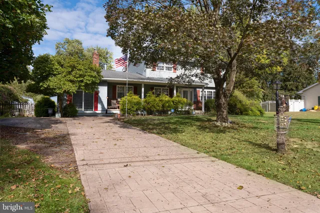 a front view of a house with a yard and potted plants
