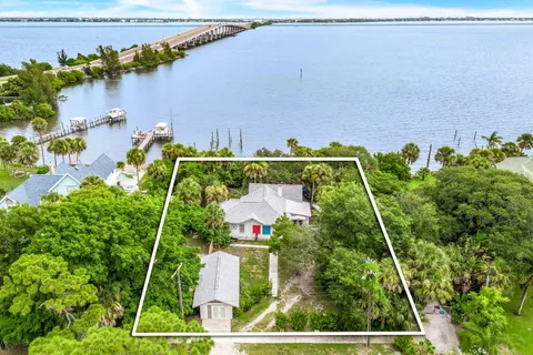 an aerial view of a house with a yard and lake view