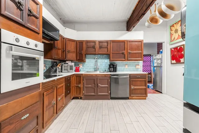a kitchen with stainless steel appliances granite countertop a refrigerator and a stove top oven