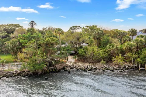 an aerial view of a house with a yard and lake view