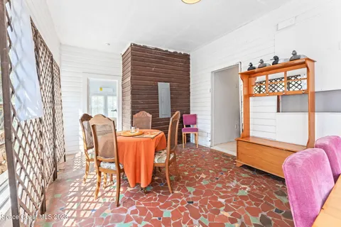 a living room with furniture and a refrigerator