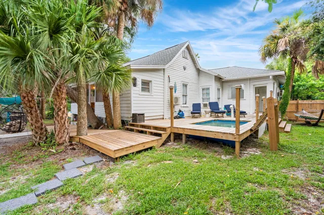 an aerial view of residential house with outdoor space and trees all around