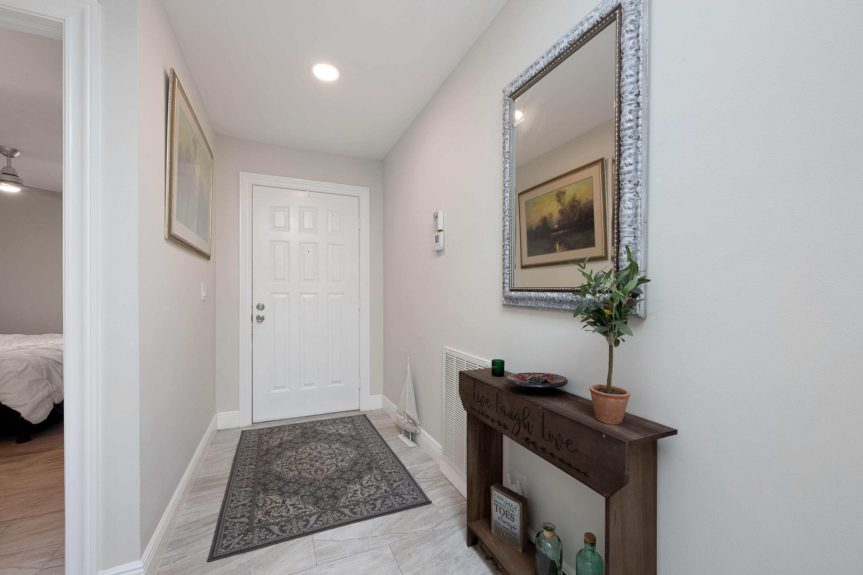 7 Ridge Pointe Drive, Unit C Boynton Beach, FL 33435 - Photo 2 of 29 a view of an entryway with table and mirror