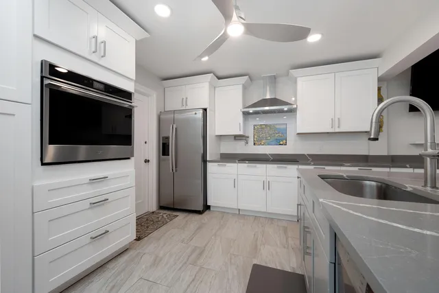 a kitchen with stainless steel appliances a refrigerator stove and white cabinets