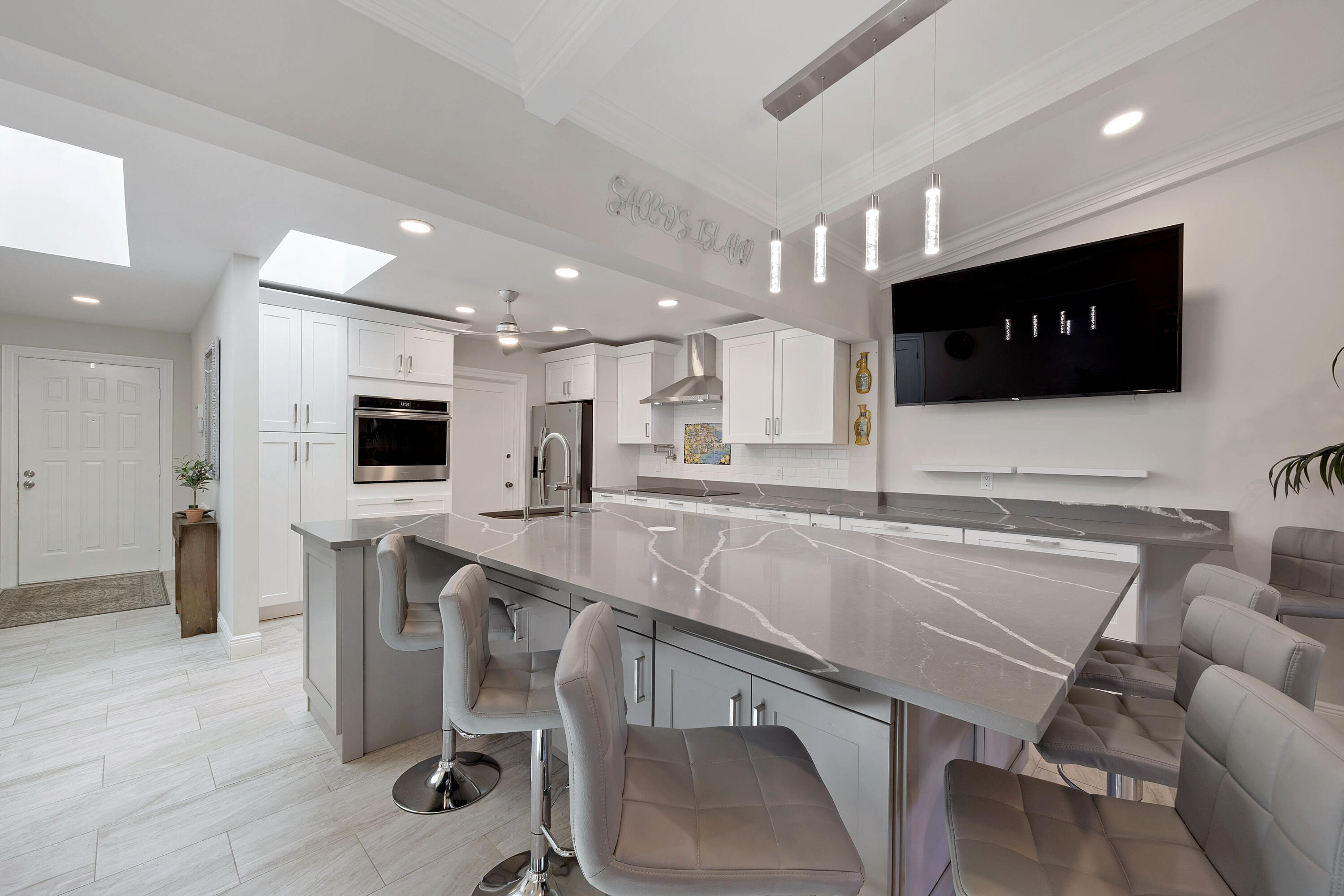 7 Ridge Pointe Drive, Unit C Boynton Beach, FL 33435 - Photo 8 of 29 a kitchen with a table chairs refrigerator and microwave