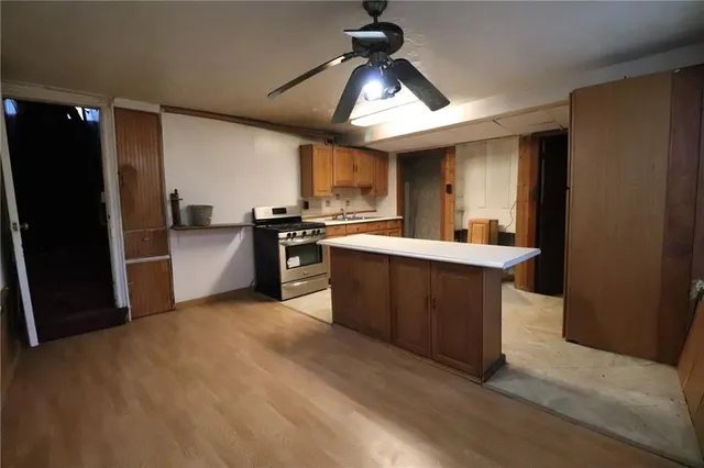 a large kitchen with stainless steel appliances a sink dishwasher stove refrigerator and cabinets