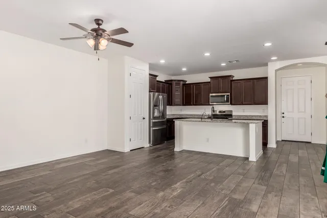 a view of kitchen with refrigerator and white cabinets