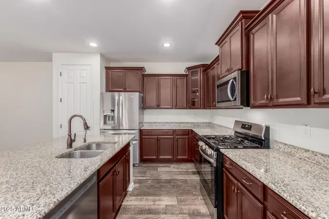 a kitchen with stainless steel appliances granite countertop a sink stove and cabinets