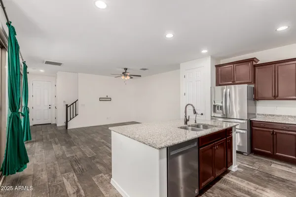 a kitchen with stainless steel appliances granite countertop a sink stove and refrigerator